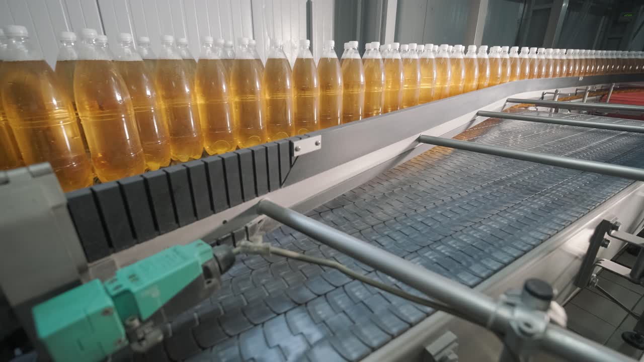 현대 음료 공장에서 주스 또는 물을위한 병을 가진 컨베이어 벨트 - 달한 소다 물의 현대 생산