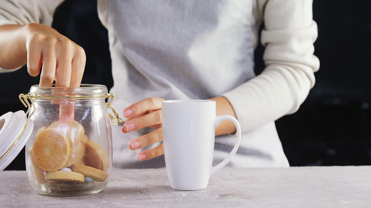 mujer sumergiendo una galleta en una taza 4k