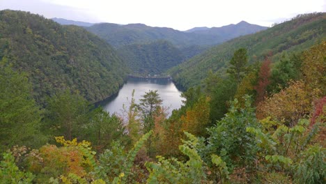 Una-Presa-Y-Un-Lago-Rodeados-Por-El-Parque-Nacional-De-Las-Grandes-Montañas-Humeantes-Con-Pintorescos-árboles-De-Otoño-Presa-De-Calderwood-Filmada-Desde-El-Mirador-Panorámico-De-La-Cola-Del-Dragón