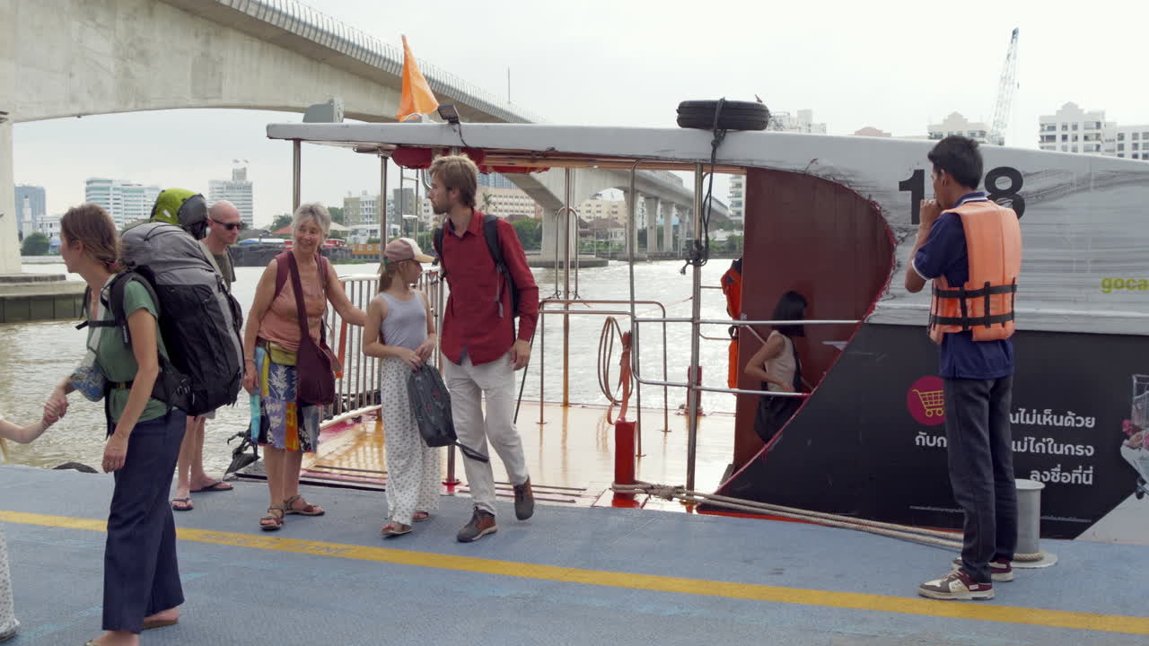Tourists get off a boat after taking a boat tour on the Chao Phraya River, Thailand