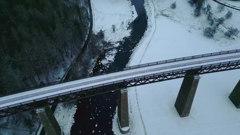 Un-Alto-ángulo-De-Vista-Del-Antiguo-Puente-Ferroviario-Y-El-Río-Congelado-En-El-Campo-Invernal