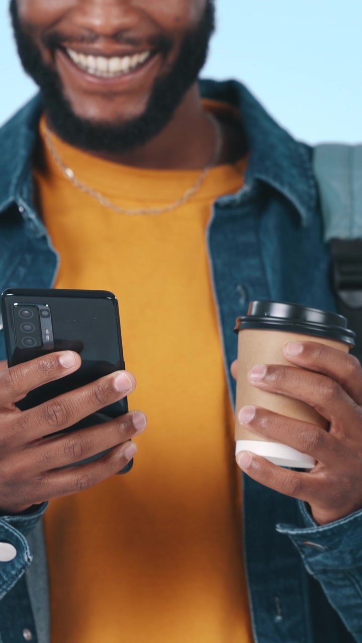 Smiling Young Man Using Smartphone and Holding Coffee Cup