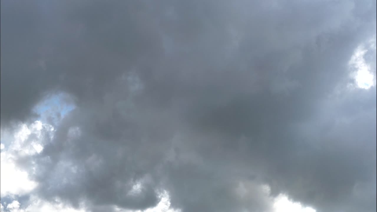Dramatic time lapse of blue sky with moving white clouds changing to grey dark clouds during sunny day