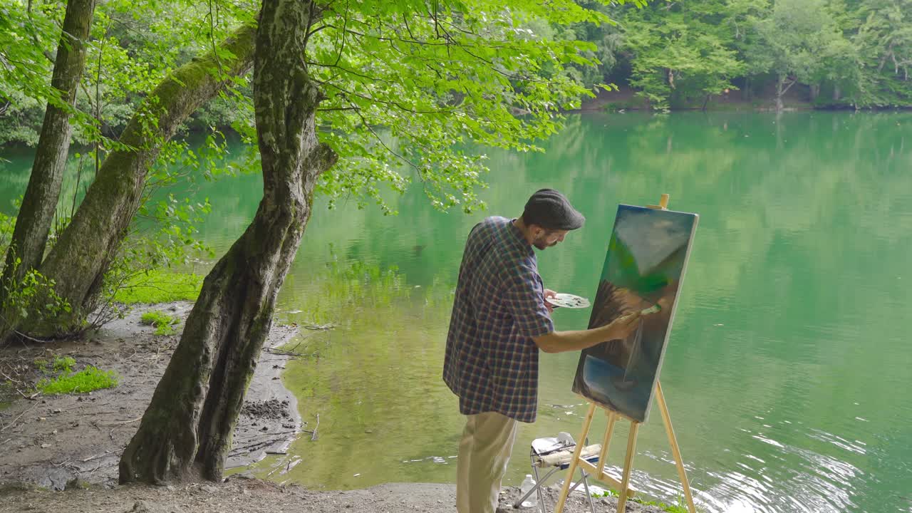 화가 숲에서 그림을 그리고 있습니다.