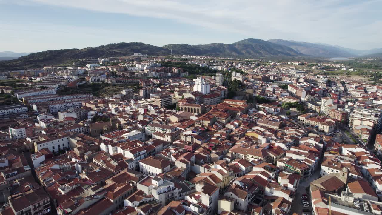Aerial view circling Plasencia walled market city in the province of C&aacute;ceres under Spanish mountain range