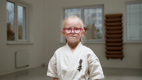 chica en kimono blanco en la clase de artes marciales