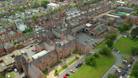 wide overhead aerial video of methodist college belfast, in northern ireland, uk on a bright and sunny day. filmed in 4k, 60fps and with rec709 color.