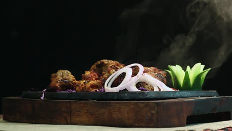 close-up shot roasted chicken bbq on round table with smoke black background