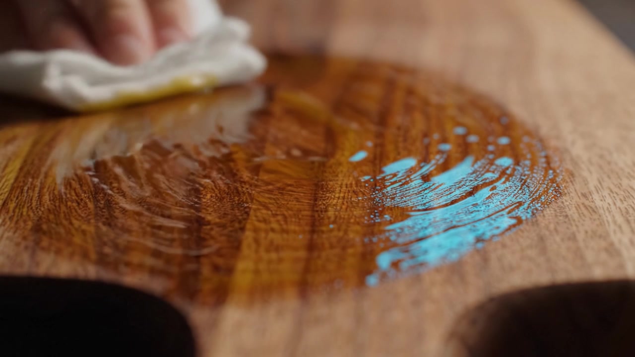 Limpieza y mantenimiento de una superficie de madera con un paño, mostrando el brillo y el cuidado involucrados en preservar su belleza y apariencia natural