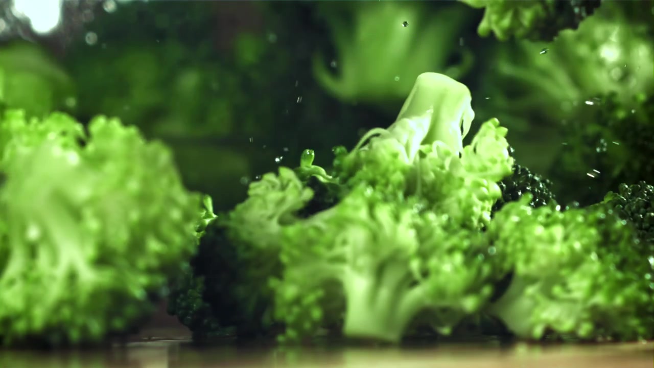 Cimette di broccoli freschi che cadono e schizzano in slow motion