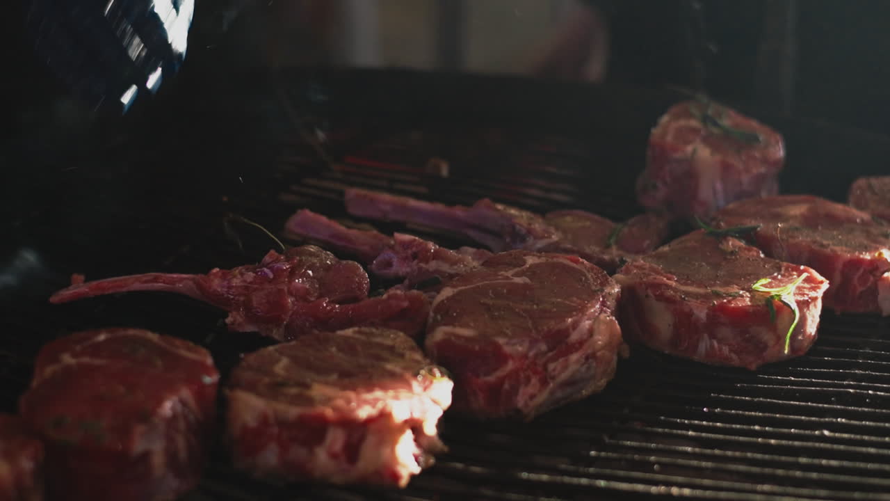hombre de primer plano manos cocinando carne afuera. chef poniendo costillas de carne en la parrilla