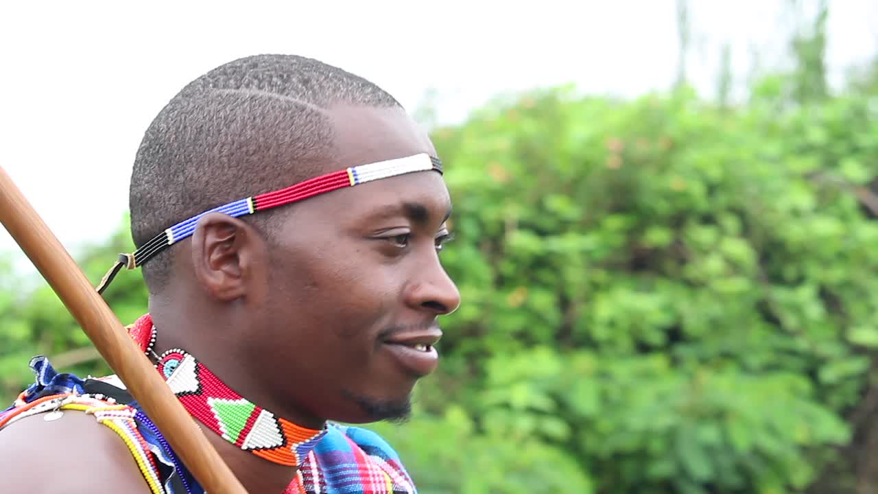 젊은 마사이족 남자는 웃고 있는 동안 음악을 들으면서 행복하다