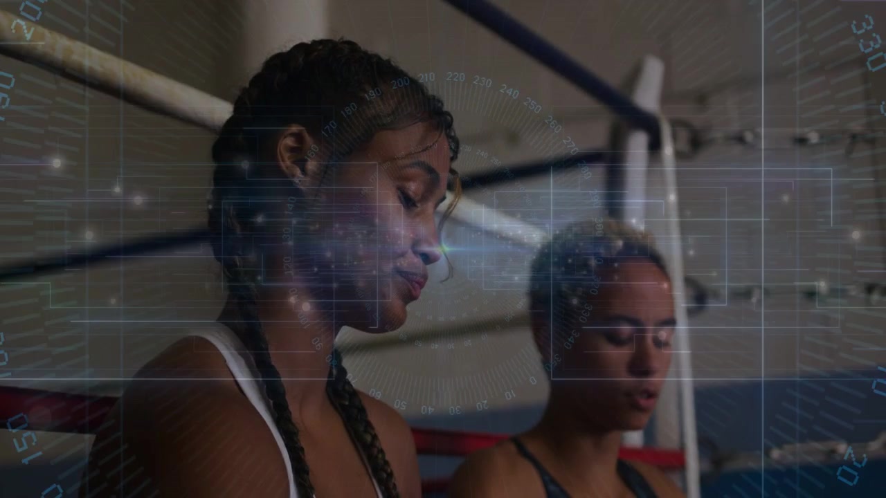 Two women in boxing corner, one wrapping hands for training, other watching HUD tracking tension