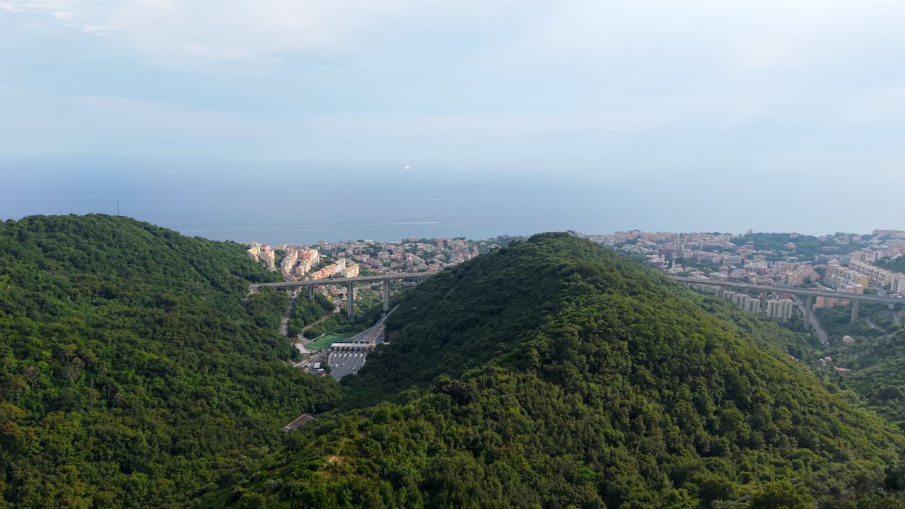 Panorama urbano di Genova visto dall'alto, con rigogliose colline in primo piano