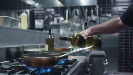 el cocinero añadiendo vino blanco a la sartén