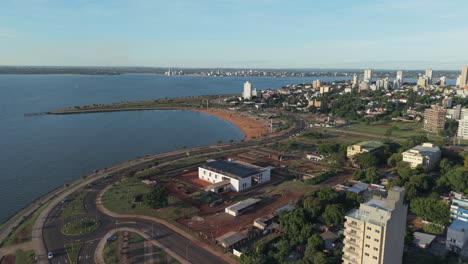 drone view of posadas, misiones, argentina, features bahía el brete, waterfront boulevard, urban buildings, green areas, and the paraná river, with visible city infrastructure, real time.
