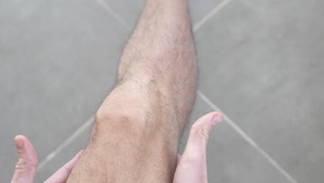 pov shot of a man rubbing his knee to relieve pain and inflammation