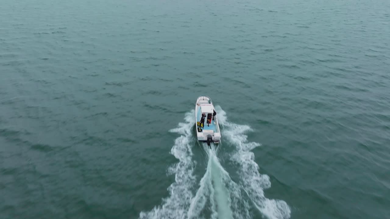 Aerial tracking shot of a scientific boat sailing to the location at Sete