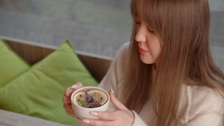 Woman enjoying a cup of herbal tea in a cozy cafe