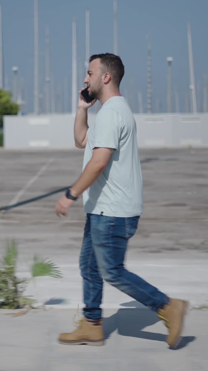 Man walking and talking on phone in urban marina setting