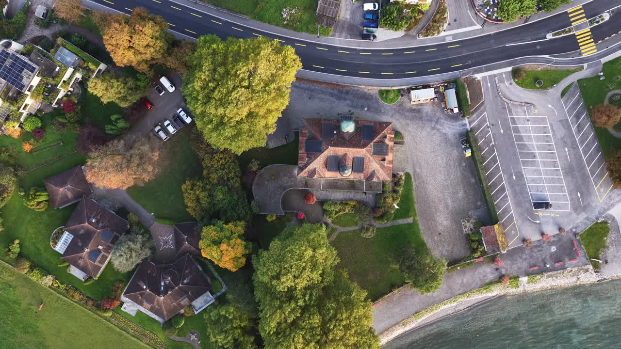 Top-down drone view moving over the lakeshore toward the city near Walensee in Walenstadt, Switzerland