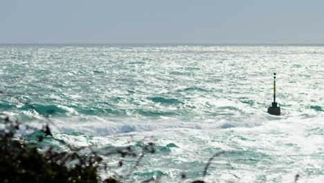 大海大波与阳光闪耀压碎在岸上, 枢机标志在暴风雨的天气, 聚焦拉