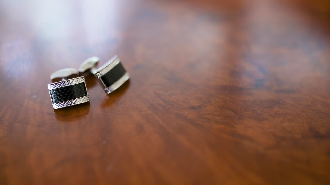 Elegant Silver and Black Cufflinks on a Wooden Table