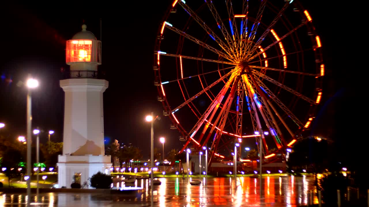 Ferris wheel and lighthouse in the Miracle Park at Night on the embankment of Batumi