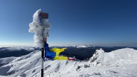 bandera rasgada soplada por el viento en la montaña del pico ciucas de rumania durante el invierno