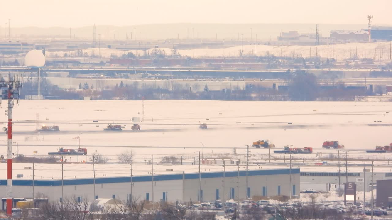 공항의 눈 인 풍경과 소방차와 유지보수 차량을 포함한 여러 서비스 차량이 활주로에서 적극적으로 이동하여 안전과 운영을 보장합니다.