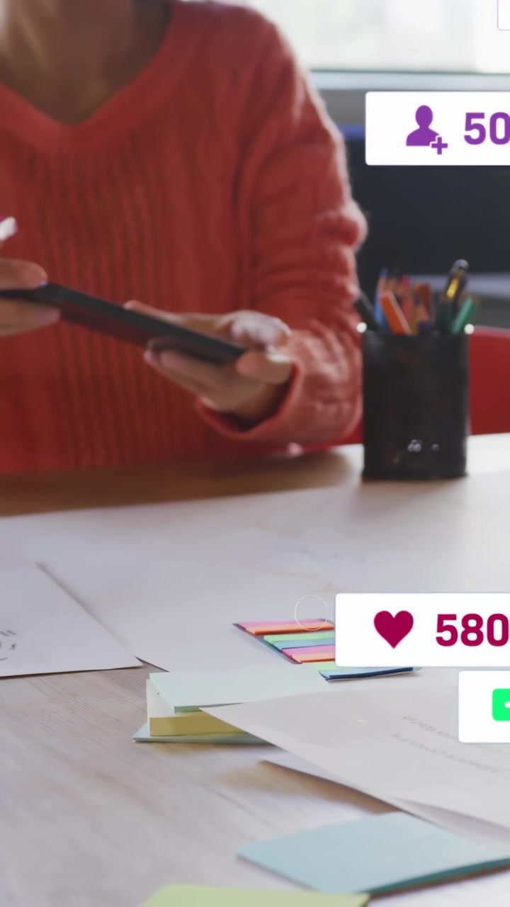 Video verticale: Donna che tocca il telefono con un pennarello, generando like e follower animati per il marketing.