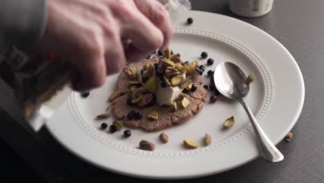 man putting toppings on a vegan cassava cake