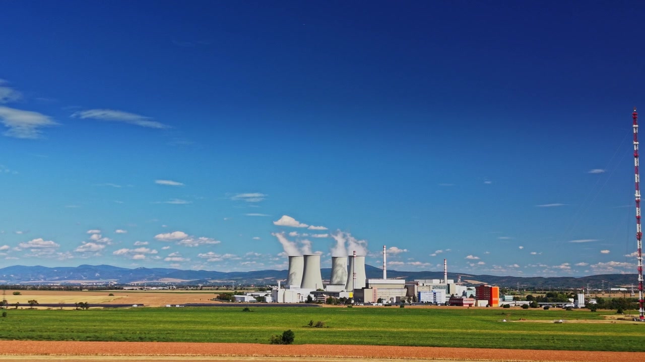 冷却塔と空に立ち上る蒸気を伴う原子力発電所