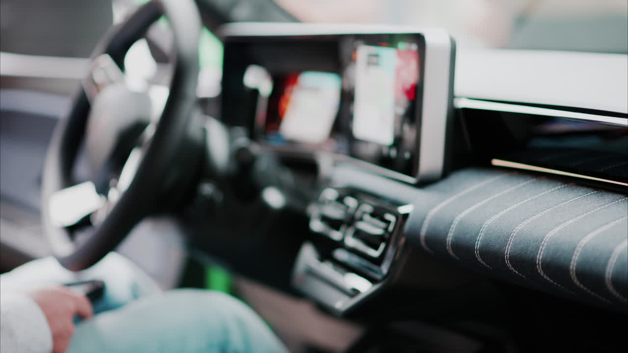 Blurry view of a man sitting in the interior of a new car