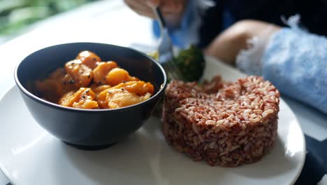 brown rice and fish in a bowl on table ,