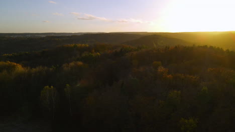 Vuelo-Aéreo-Sobre-El-Hermoso-Bosque-Otoñal-En-El-Campo-Montañoso-Rural-Ondulado-Al-Atardecer