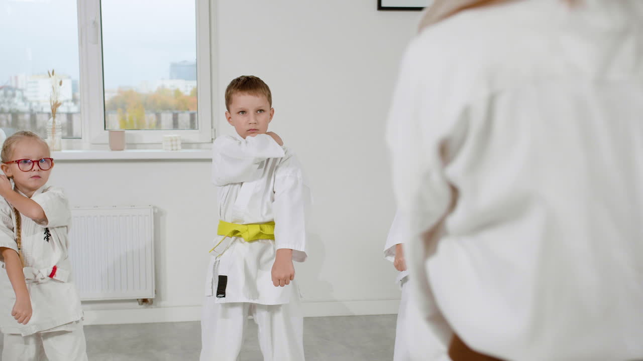 niños en kimono blanco en la clase de artes marciales