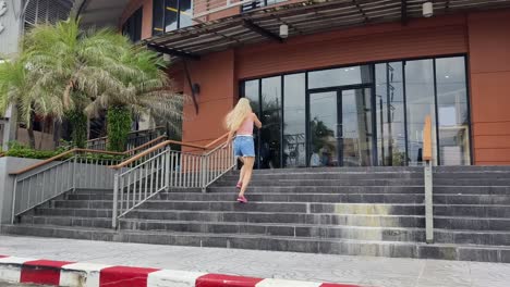 mujer subiendo las escaleras fuera de una tienda de ropa