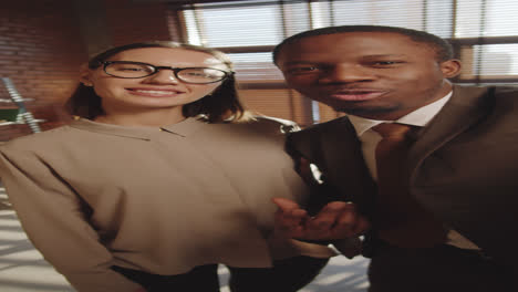 multiethnic coworkers talking on video call in office