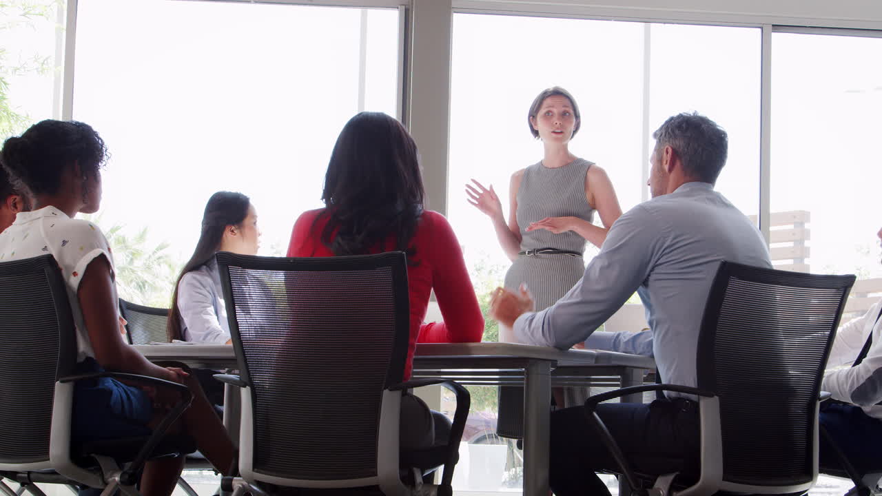 한 젊은 사업가 여성 이 서서 회의 에서 연설 하고 있다