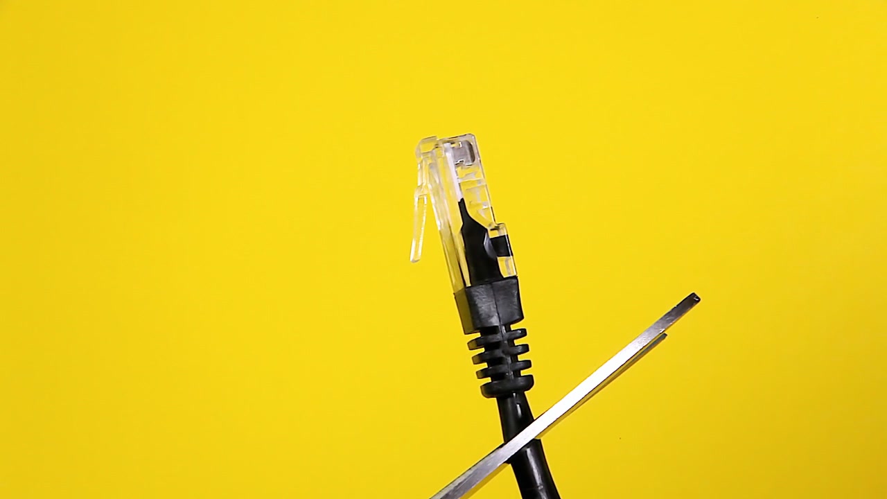 Cutting a black network cable with sharp scissors