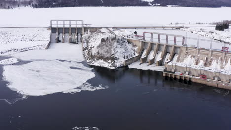 aerial: moving left over mactaquac dam on cold winter day
