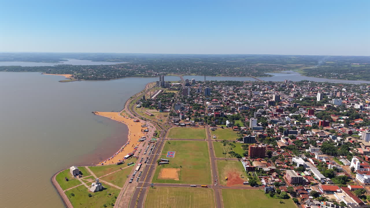 Experience a panoramic aerial view of Encarnacion, Paraguay, as beachgoers and tourists enjoy a sunny day at Playa San Jose.
