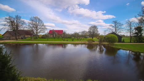 A-timelapse-shot-of-houses-during-daytime-near-the-lake-on-a-sunrise