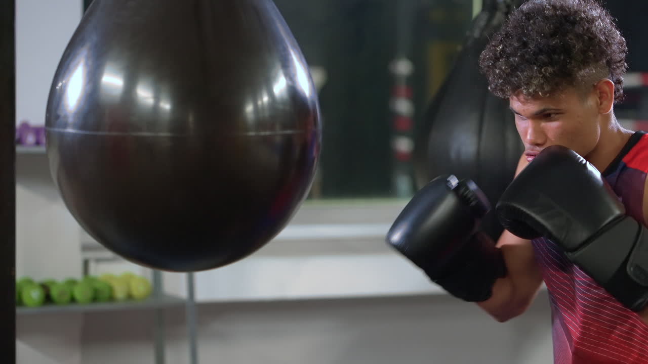 젊은 권투 선수가 권투 봉투를 가지고 훈련하고 있습니다.