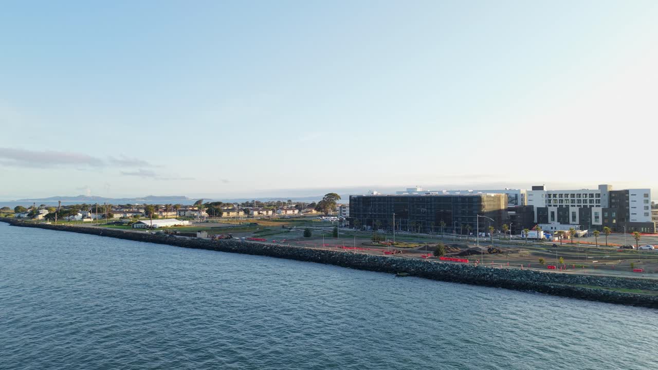 A panning aerial view of the shore of Treasure Island after sunrise in San Francisco California.