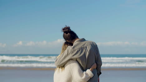 young caucasian couple spending time at seashore