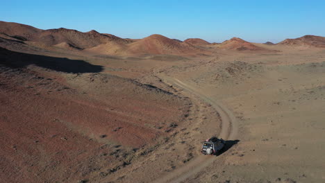 filmación cinematográfica de drones de un auto solitario que viaja en el cañón charyn, kazajstán