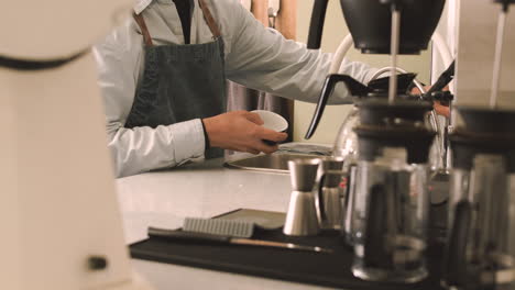 dos camareros multiétnicos irreconocibles lavando tazas de café