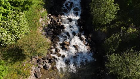 Top-down-aerial-view-of-a-mountain-river-flowing-over-rocks-and-stones-in-Weesen,-Switzerland,-capturing-the-concept-of-natural-dynamism-and-untouched-wilderness